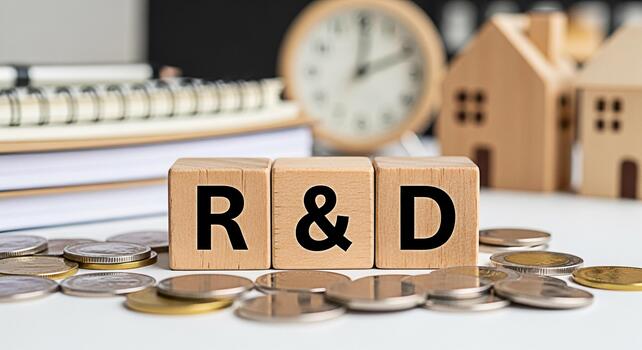 Wooden blocks spelling RD surrounded by coins on a white table symbolizing investment in research and development for business growth and innovation in a financial setting creating a sense of opportun photo
