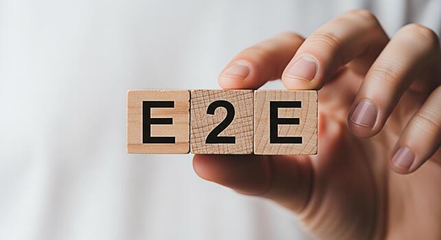 Closeup of a hand holding wooden blocks spelling E2E against a blurred background representing endtoend solutions business processes and efficient communication in a modern business environment photo