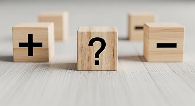 Wooden blocks displaying a plus question mark and minus sign on a white wooden surface representing decisionmaking problemsolving and weighing pros and cons in a bright and clean setting photo