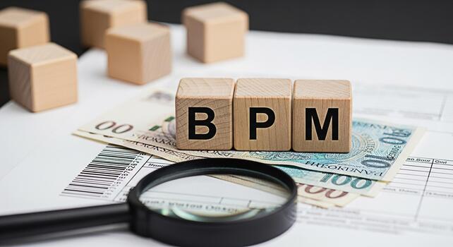 Wooden blocks spelling BPM resting on Polish currency with a magnifying glass in a financial setting representing business process management and financial analysis with a focus on efficiency and opti photo