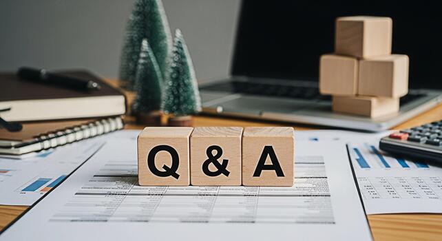 Wooden blocks displaying QA on a desk with financial reports a laptop and Christmas trees representing business questions and answers in a festive office environment fostering clarity and understandin photo
