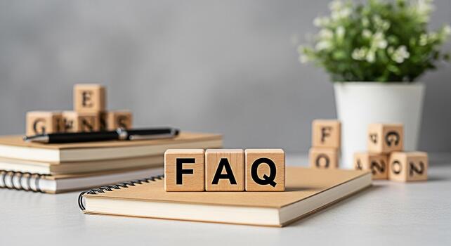 Wooden blocks spelling FAQ resting on a notebook in a bright clean office environment conveying a sense of clarity knowledge and readily available information for customers and website visitors photo
