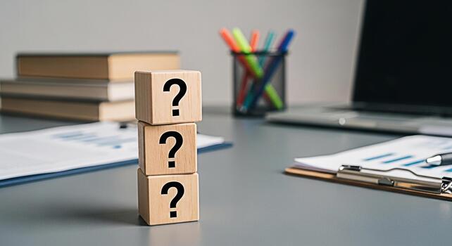 Stack of wooden blocks displaying question marks on a gray office desk symbolizing uncertainty and problemsolving in a professional environment promoting curiosity and the search for answers in busine photo