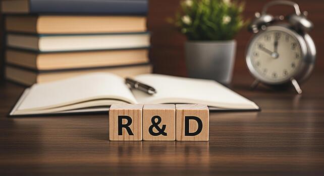 Wooden blocks spelling RD resting on a wooden desk with books a pen and an open notebook symbolizing research and development in an academic or business environment conveying innovation and progress photo