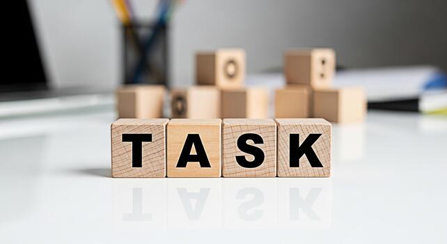 Wooden blocks spelling TASK on a white desk representing project management and workload organization in a modern office environment conveying a sense of focus and productivity photo
