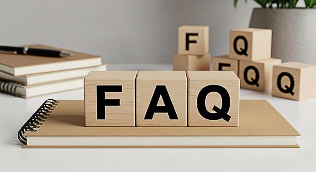 Wooden blocks displaying FAQ on a notebook in a bright minimalist office setting representing frequently asked questions and readily available information for customer support and business solutions photo