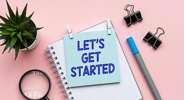 Inspirational message Lets Get Started displayed on a notepad in a bright creative workspace surrounded by office supplies conveying a positive and motivational atmosphere for new projects and beginni photo