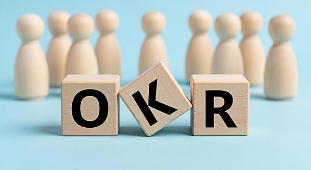 Wooden figures standing behind OKR blocks on a blue surface representing objectives and key results in a business setting conveying a sense of teamwork goalsetting and strategic planning for success photo