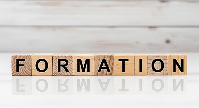 Wooden blocks spelling FORMATION on a white surface reflecting the word symbolizing the process of building creating and developing a strong foundation for success and growth in a bright environment photo
