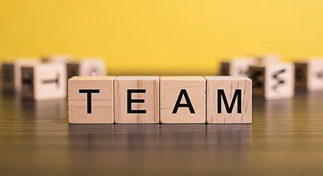 de madera bloques ortografía equipo en un oscuro de madera superficie en contra un brillante amarillo antecedentes simbolizando colaboración unidad y el importancia de trabajo en equipo en lograr común metas foto