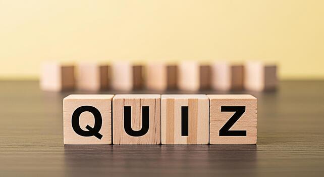 Wooden blocks spelling QUIZ on a dark wooden surface against a yellow background representing a test of knowledge and skills creating a playful and engaging learning environment photo