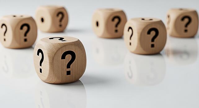 Wooden dice displaying question marks on a reflective white surface symbolizing uncertainty and the need for answers in business decisions and personal life creating a mood of curiosity and challenge photo