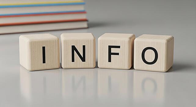 Wooden blocks spelling INFO on a gray surface with books in the background conveying knowledge and information in a clean educational setting ideal for learning and reference materials photo