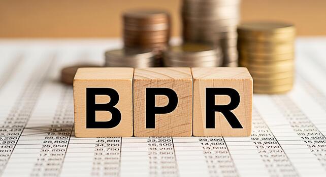Wooden blocks displaying BPR on a financial spreadsheet with stacks of coins symbolizing Business Process Reengineering for improved efficiency and profitability in a corporate environment photo