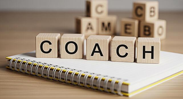 Wooden blocks spelling COACH on a notebook symbolizing guidance and mentorship in a learning environment fostering a supportive and motivational atmosphere for personal and professional development photo