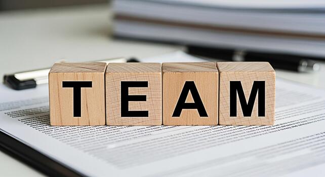 Wooden blocks spelling TEAM on a document in a bright office symbolizing collaboration and unity fostering a sense of teamwork and shared goals in a professional environment promoting success photo