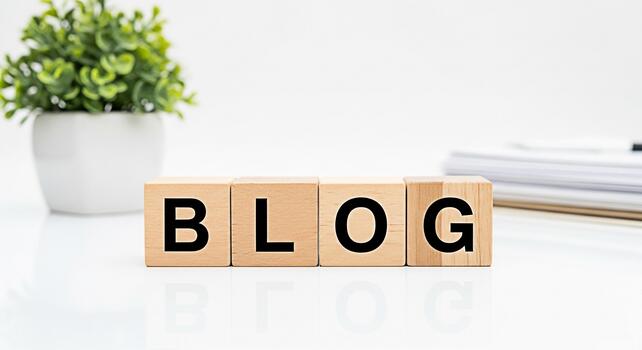 Wooden blocks spelling BLOG on a white desk next to a potted plant and stack of papers symbolizing blogging content creation and online communication in a clean and modern workspace photo