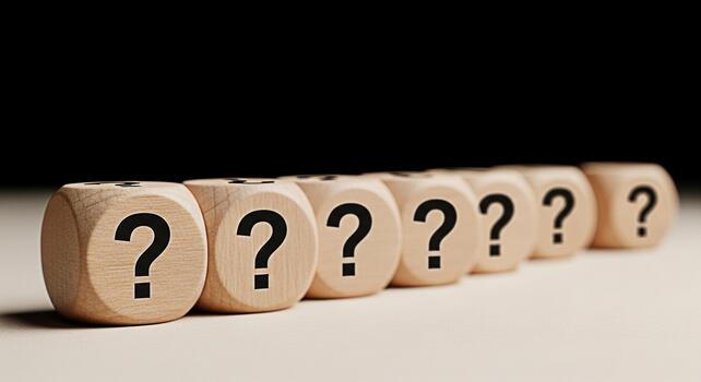 A row of wooden dice displaying question marks on a neutral surface against a dark background symbolizing uncertainty inquiry and the search for answers in business and personal life photo