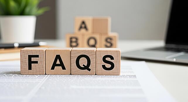 Wooden blocks spelling FAQs on a white desk in a bright office symbolizing information and customer support with a laptop and plant in the background creating a professional and helpful atmosphere photo