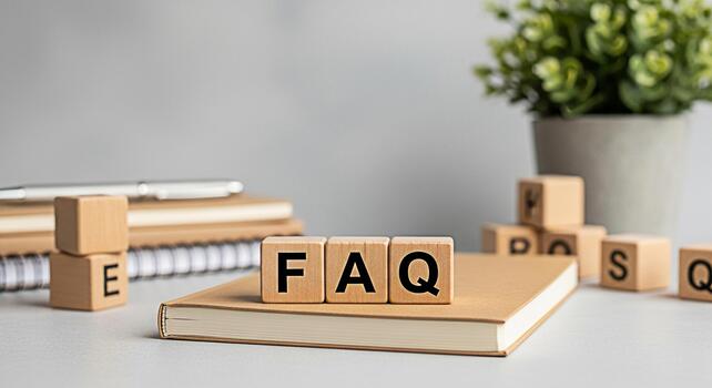 Wooden blocks spelling FAQ resting on a notebook in a bright minimalist office setting conveying a sense of clarity information and accessibility for frequently asked questions and support resources photo