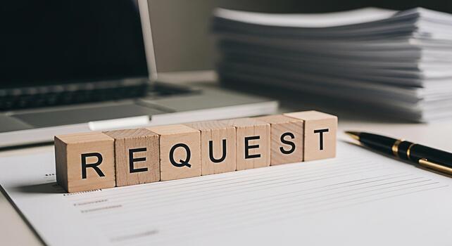 Wooden blocks spelling REQUEST resting on a document in a bright office symbolizing a formal inquiry and the need for information or action in a professional and organized environment photo