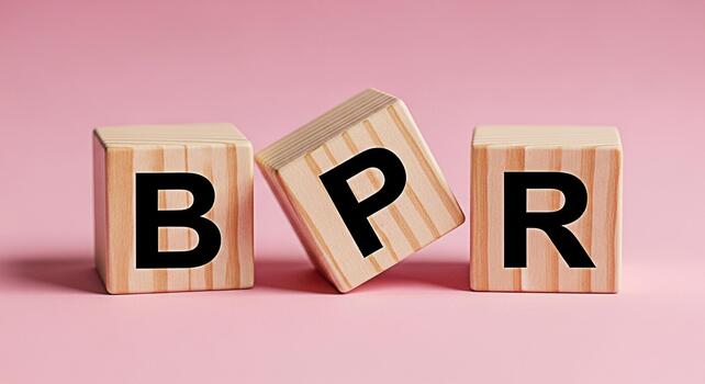 Wooden blocks spelling out BPR on a pink surface representing business process reengineering in a clean studio environment conveying a message of efficiency and optimization photo