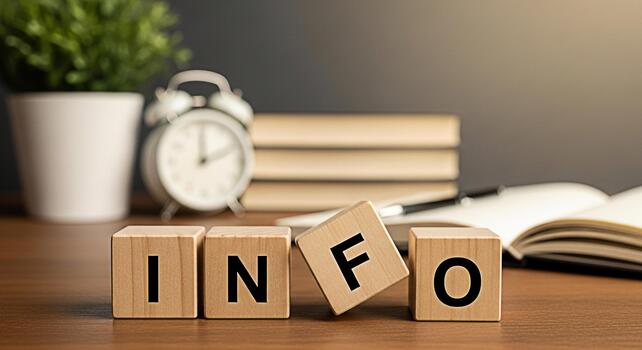 Wooden blocks spelling INFO on a wooden desk in a study room conveying a sense of knowledge and learning with books a clock and a plant in the background creating an informative and educational atmosp photo