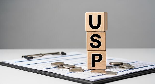 Wooden blocks displaying USP on a clipboard with financial data and coins representing unique selling proposition analysis in a business setting conveying financial strategy and competitive advantage photo