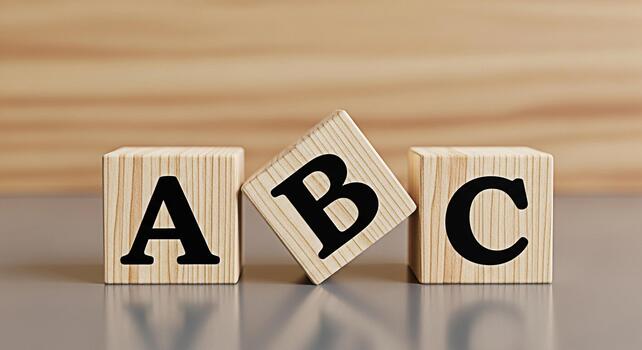 Wooden alphabet blocks displaying A B and C on a gray surface against a wooden background representing early childhood education and learning the basics with a playful and educational concept photo