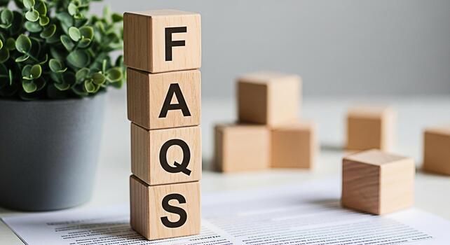 Wooden blocks spelling FAQs stacked on a document in a bright office setting representing frequently asked questions and a helpful informative and accessible customer support experience photo