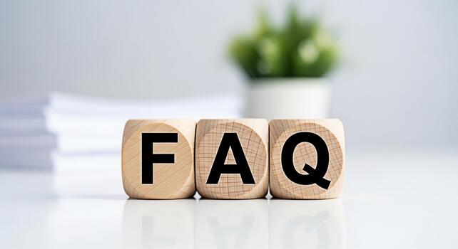 Wooden blocks displaying FAQ on a white table symbolizing frequently asked questions and providing information in a clean professional setting promoting clarity and customer support photo