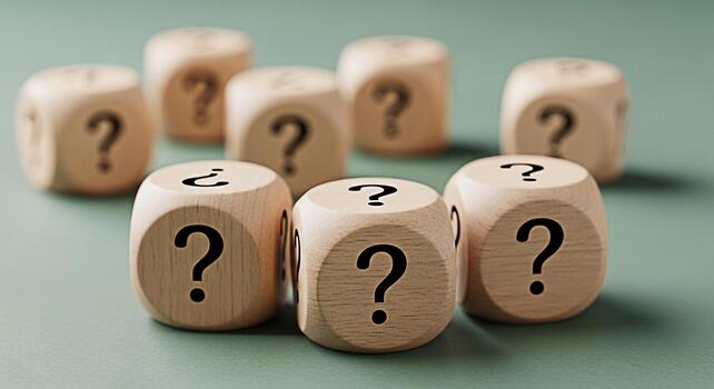 Group of wooden dice displaying question marks on a green surface symbolizing uncertainty and the search for answers in a complex and confusing world creating a mood of curiosity and inquiry photo