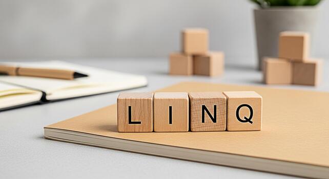 Wooden blocks spelling LINQ resting on a notebook in a bright minimalist office setting representing a modern approach to data querying and manipulation with a clean organized and efficient workflow photo