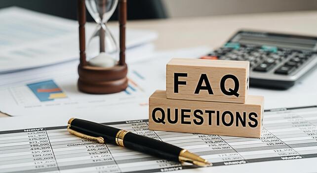 Closeup of wooden blocks spelling FAQ QUESTIONS on financial documents in a bright office with a pen calculator and hourglass representing time management and problemsolving for business success photo