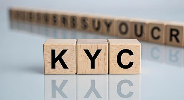 Wooden blocks spelling KYC on a reflective surface representing Know Your Customer compliance and due diligence in a financial setting conveying trust and security in business transactions photo