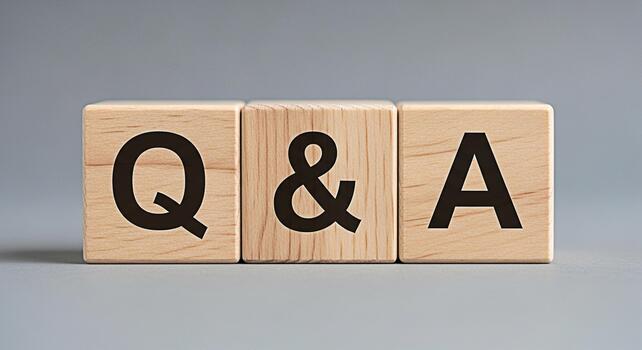 Wooden blocks displaying Q A on a gray background representing questions and answers knowledge sharing and information exchange in a simple and clean studio setting conveying clarity and understanding photo