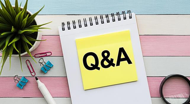 Notepad displaying QA on a yellow sticky note surrounded by office supplies on a colorful striped desk representing questions and answers knowledge sharing and problemsolving in a creative workspace photo