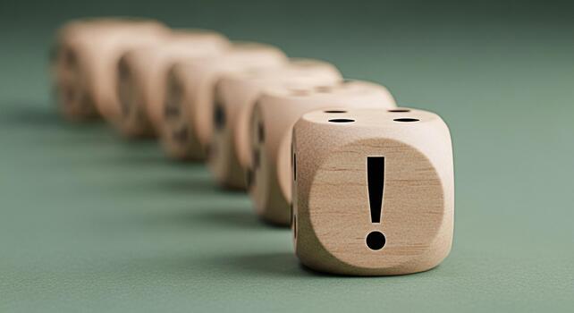 A row of wooden dice displaying an exclamation mark on a green surface symbolizing urgency and attention to detail in a minimalist and focused environment highlighting the importance of critical think photo