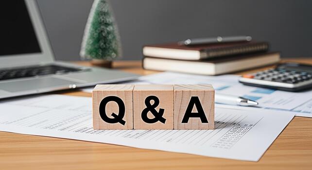 Wooden blocks displaying Q A on a wooden desk in a modern office environment symbolizing knowledge sharing and problemsolving with a laptop documents calculator and books in the background photo