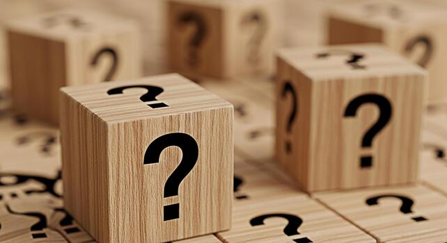 Wooden cubes displaying question marks on a wooden surface representing uncertainty and the need for answers creating a sense of curiosity and intrigue in a neutral setting photo
