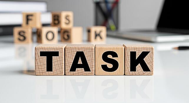 Wooden blocks spelling out TASK on a white desk in a bright office symbolizing project management and the importance of completing assignments with focus and efficiency for business success photo
