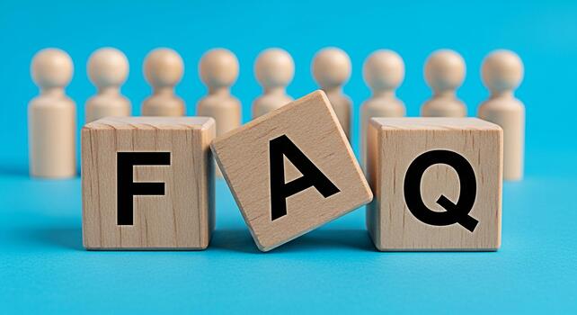 Wooden blocks displaying FAQ on a blue surface with blurred wooden figures representing frequently asked questions customer support and information resources in a simple and clear presentation photo