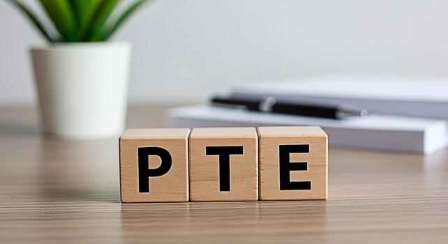 PTE exam preparation concept with wooden blocks displaying PTE letters on a desk representing English language proficiency test readiness and a focused learning environment for academic success photo