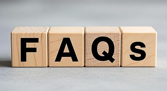 Wooden blocks displaying FAQs on a gray surface representing frequently asked questions and information resources conveying clarity and support for customers and users in a simple and accessible way photo