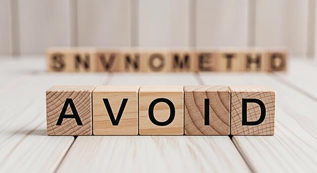 Wooden blocks spelling AVOID on a white wooden surface suggesting prevention and caution in a clean minimalist setting emphasizing the importance of strategic planning and risk management photo