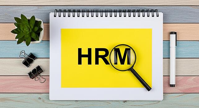 HRM text under magnifying glass on yellow paper in a notebook symbolizing human resources management and organizational structure on a colorful wooden desk representing business and corporate strategy photo