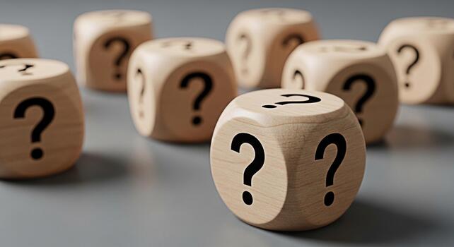 Wooden dice displaying question marks on a gray surface representing uncertainty and the search for answers in a business context creating a mood of inquiry and problemsolving photo