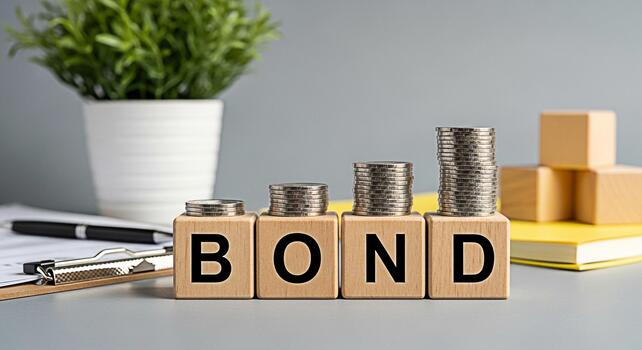 Stacks of coins increasing on wooden blocks spelling BOND on a gray table with a plant and documents symbolizing investment growth and financial security in a stable environment photo