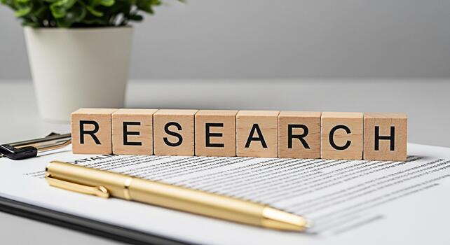 Wooden blocks spelling RESEARCH on a document with a gold pen in a bright office setting representing investigation analysis and the pursuit of knowledge with a focus on accuracy and detail photo