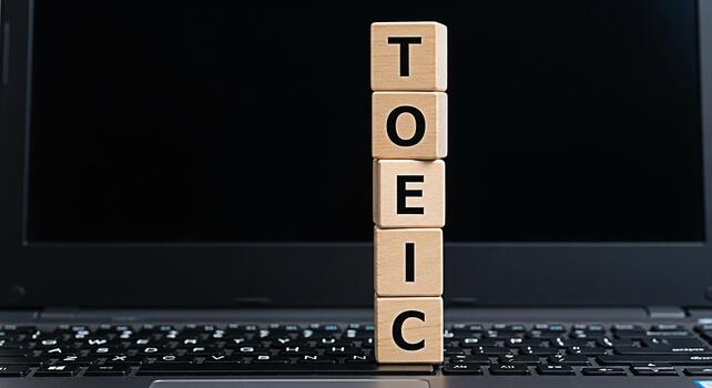 TOEIC wooden blocks stacked on a laptop keyboard in a learning environment representing test preparation and educational success symbolizing language proficiency and career advancement photo